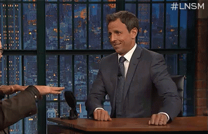 A Man In A Suit And Tie Is Sitting At A Desk With The Words Knock On Written On It GIF