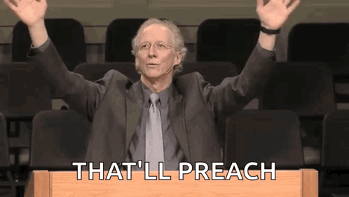 A Man In A Suit And Tie Is Sitting At A Podium With His Arms In The Air And Says That 'Ll Preach GIF