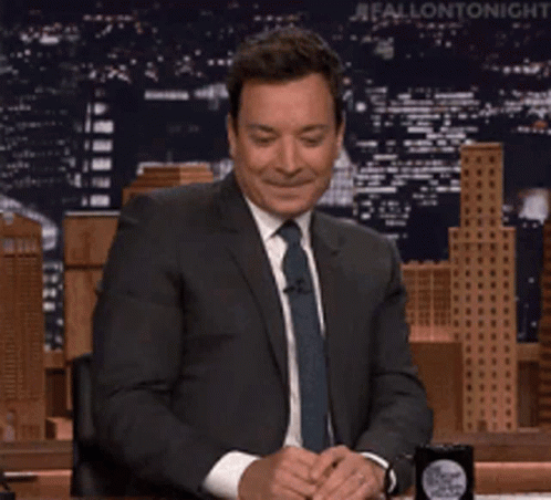 A Man In A Suit And Tie Is Sitting At A Table And Says Maaaa Maybe GIF