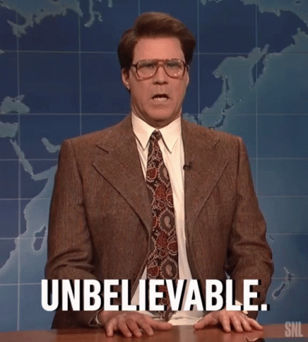 A Man In A Suit And Tie Is Sitting At A Table And Says Unbelievable . GIF
