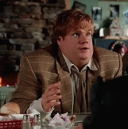 A Man In A Suit And Tie Is Sitting At A Table In A Restaurant Talking To Someone . GIF