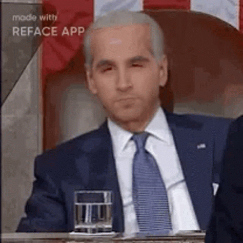 a man in a suit and tie is sitting at a table .