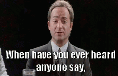 A Man In A Suit And Tie Is Sitting At A Table With A Glass Of Water And A Quote . GIF