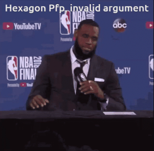 A Man In A Suit And Tie Is Sitting At A Table With A Microphone In Front Of A Sign That Says Youtube Tv GIF