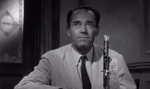 a man in a suit and tie is sitting at a table with a microphone in front of him