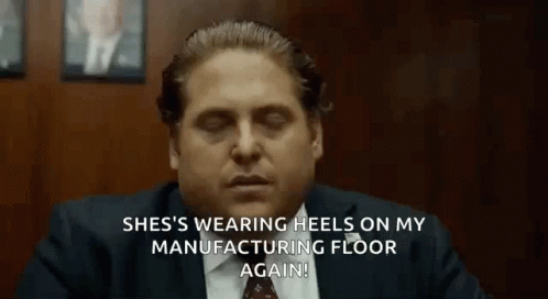 a man in a suit and tie is sitting at a table with his eyes closed and talking .
