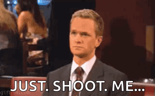 A Man In A Suit And Tie Is Sitting At A Table With His Hand On His Face . GIF