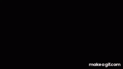 A Man In A Suit And Tie Is Sitting At A Table With His Head In The Air . GIF