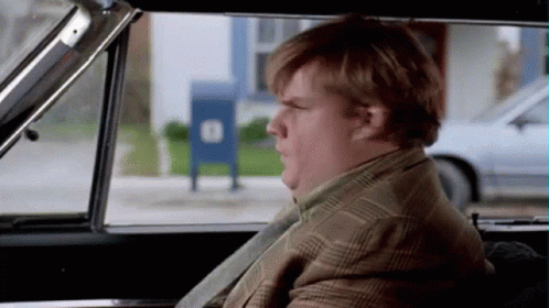 A Man In A Suit And Tie Is Sitting In A Car Looking Out The Window .. GIF