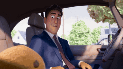 a man in a suit and tie is sitting in a car next to a teddy bear