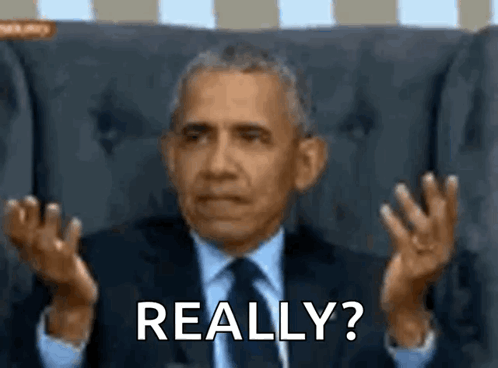 A Man In A Suit And Tie Is Sitting In A Chair And Making A Funny Face While Saying Really ? GIF