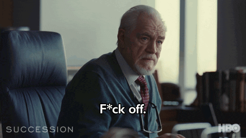 A Man In A Suit And Tie Is Sitting In A Chair And Saying F * Ck Off GIF