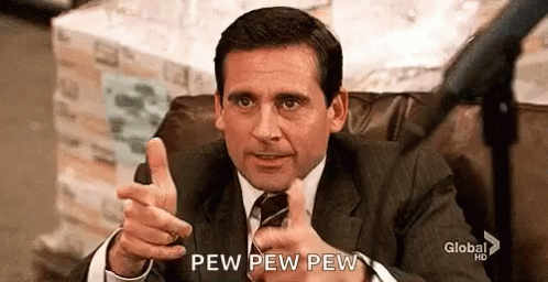 A Man In A Suit And Tie Is Sitting In A Chair Giving A Thumbs Up . GIF