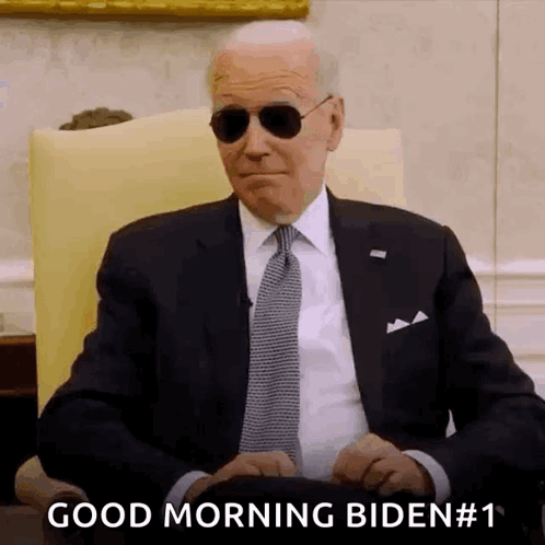Man In Suit And Tie Wearing Sunglasses Saying Good Morning Biden GIF