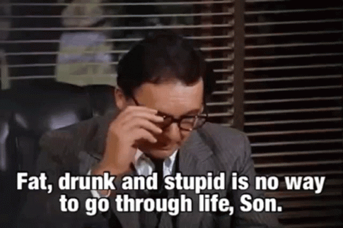 A Man In A Suit And Tie Is Sitting In A Chair With His Eyes Closed And Glasses On . GIF