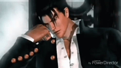 A Man In A Suit And Tie Is Sitting In A Chair With His Hand On His Face . GIF
