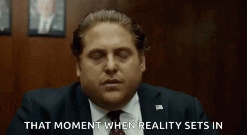 a man in a suit and tie is sitting in a room with his eyes closed and says that moment when reality sets in