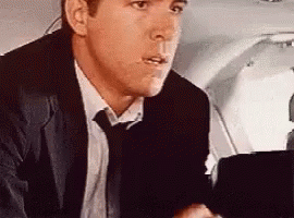 Man In Suit Sitting In Airplane Seat GIF