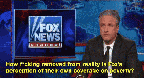A Man In A Suit And Tie Is Sitting In Front Of A Fox News Channel Sign GIF