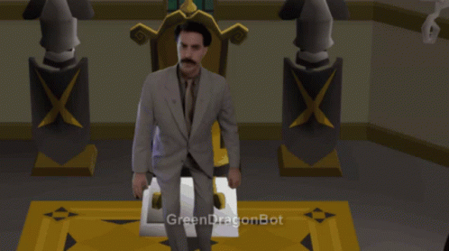 A Man In A Suit And Tie Is Sitting In Front Of A Green Dragonbot GIF