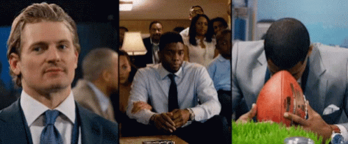 A Man In A Suit And Tie Is Sitting In Front Of A Group Of People GIF