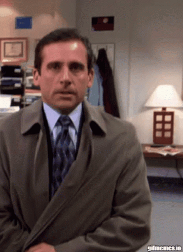 A Man In A Suit And Tie Is Sitting In Front Of A Lamp With Gifmemes.io Written On The Bottom GIF