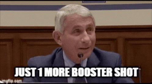 A Man In A Suit And Tie Is Sitting In Front Of A Microphone . GIF