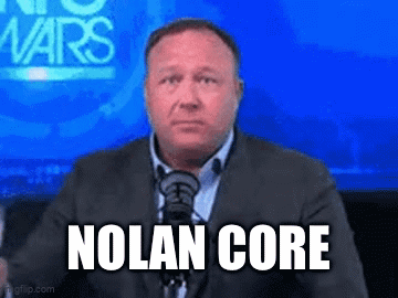 A Man In A Suit And Tie Is Sitting In Front Of A Microphone With The Words Nolan Core On His Face GIF