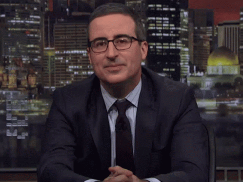 A Man In A Suit And Tie Is Sitting In Front Of A Screen That Says " Dope " GIF