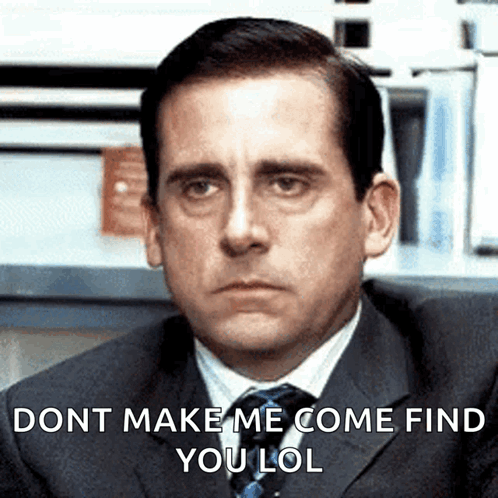 A Man In A Suit And Tie Is Sitting In Front Of A Sign That Says Dont Make Me Come Find You Lol GIF