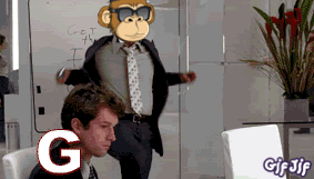 A Man In A Suit And Tie Is Sitting In Front Of A White Board With A Monkey On It GIF