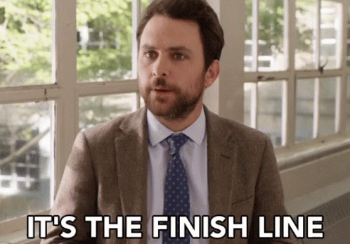A Man In A Suit And Tie Is Sitting In Front Of A Window And Saying It 'S The Finish Line . GIF