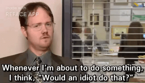 A Man In A Suit And Tie Is Sitting In Front Of A Window And Talking . GIF