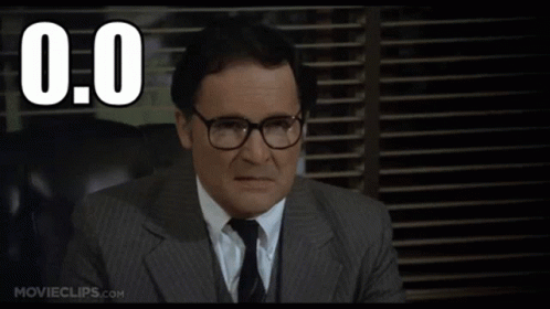A Man In A Suit And Tie Is Sitting In Front Of A Window With The Number 0.0 Written Above Him GIF