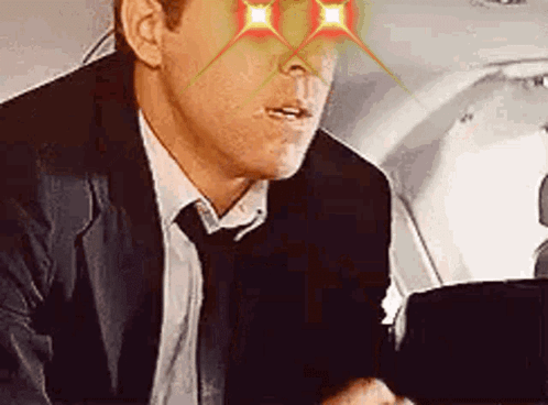 Man In Suit And Tie Sitting In Airplane GIF