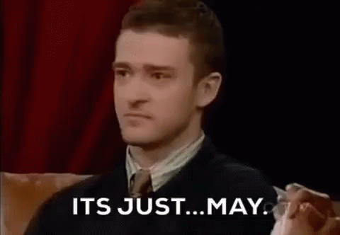 A Man In A Suit And Tie Is Sitting On A Couch And Saying `` It 'S Just May '' . GIF