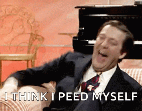 A Man In A Suit And Tie Is Sitting On A Couch And Says I Think I Peed Myself .. GIF