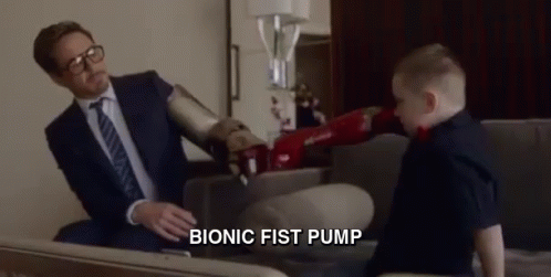 A Man In A Suit And Tie Is Sitting On A Couch Talking To A Young Boy . GIF