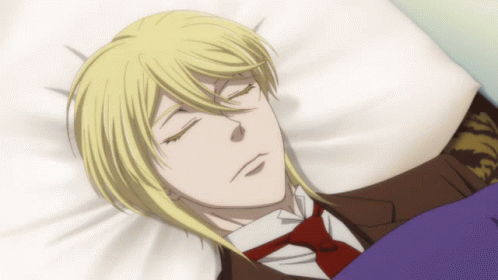A Man In A Suit And Tie Is Sleeping In A Bed With His Eyes Closed GIF