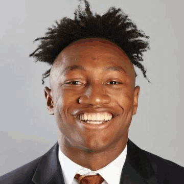 A Man In A Suit And Tie Is Smiling GIF