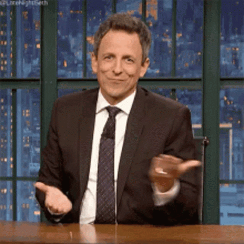 A Man In A Suit And Tie Is Smiling And Clapping GIF