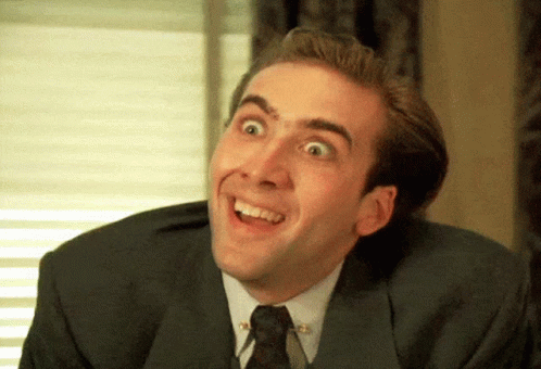 A Man In A Suit And Tie Is Smiling And Looking Up GIF
