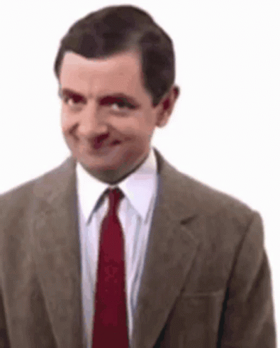 A Man In A Suit And Tie Is Smiling And Making A Funny Face . GIF