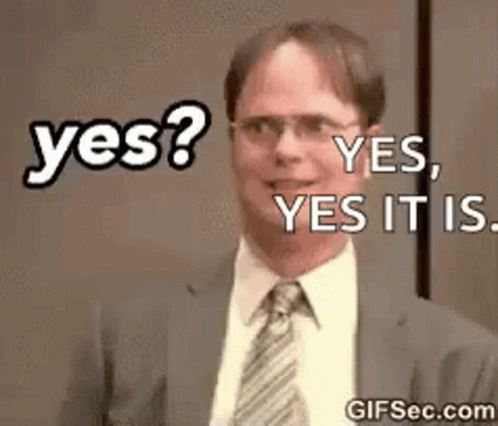 A Man In A Suit And Tie Is Smiling And Says Yes . GIF