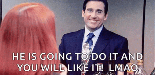A Man In A Suit And Tie Is Smiling And Talking To A Woman . GIF