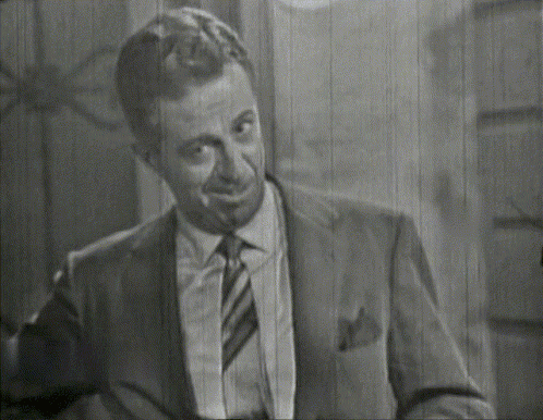 A Man In A Suit And Tie Is Smiling GIF