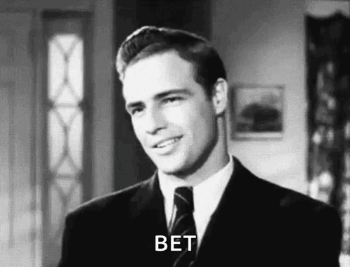 A Man In A Suit And Tie Is Smiling In A Black And White Photo And Says Bet . GIF