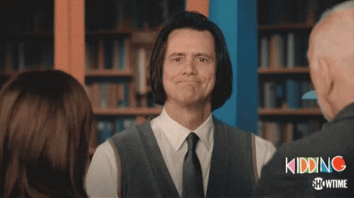 A Man In A Suit And Tie Is Smiling In Front Of A Showtime Logo GIF