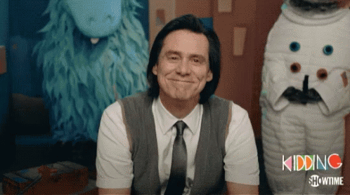 A Man In A Suit And Tie Is Smiling In Front Of A Showtime Logo GIF