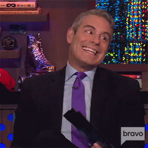 a man in a suit and tie is smiling in front of a sign that says bravo on it